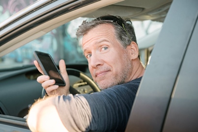 Man in car holiding cellphone